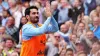 Ilkay Gundogan acknowledges fans as he warms up ahead of making his second Manchester City debut (Peter Byrne/PA).